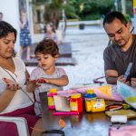 família coposta por mãe, pai e filho fazendo pinturas em guache